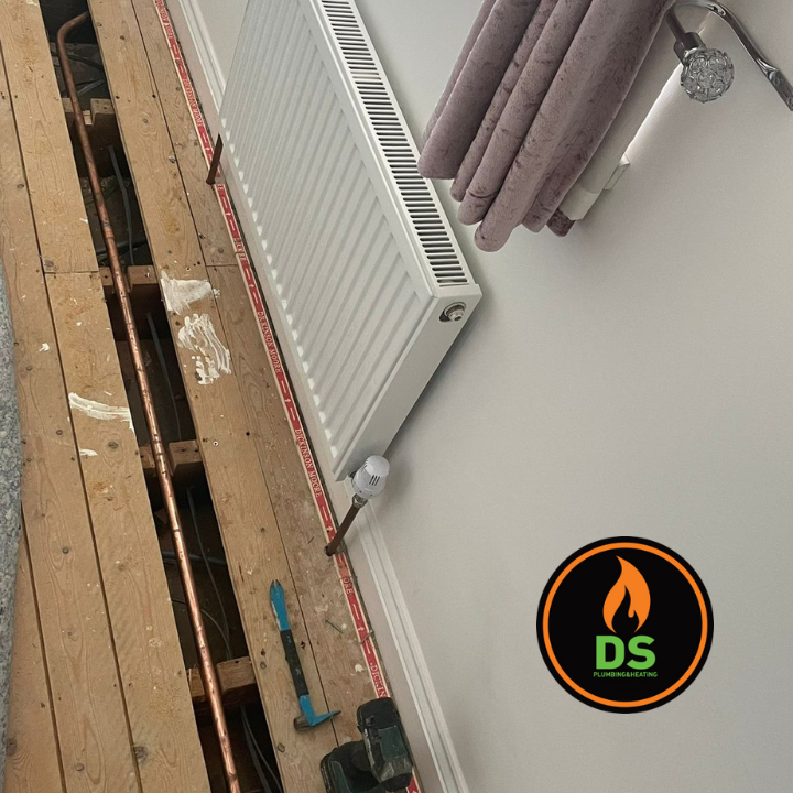 DS Plumbing and Heating repairing pipework under wooden floorboards in Desborough